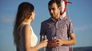 Genç bir adam, elinde bir bardak alkol olan bir kadınla flört ediyor