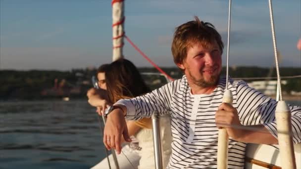 Компания молодых и симпатичных друзей наслаждается прогулкой на яхте в течение дня — стоковое видео