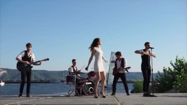 Genç müzisyenler iskelede gerçekleştirmek, onlar şarkı ve müzik aletleri