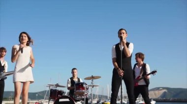 Modern müzisyenler kurumsal bir partide deniz kenarında bir şarkı gündüz gerçekleştirmek.