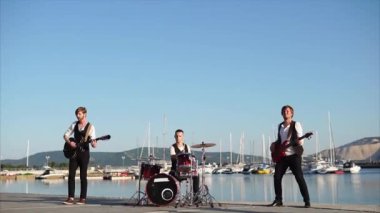 Modern müzisyenler aletleri deniz kenarında bir müzikal kompozisyon gerçekleştirmek