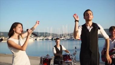 Genç müzisyenler deniz kenarında sokakta kendi grubu bir konser vermek