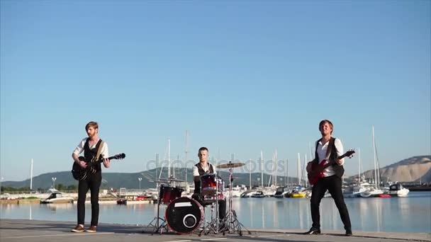 Des musiciens modernes interprètent une composition musicale sur des instruments près de la mer — Video