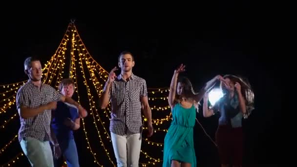 Un grupo de amigos están bailando en el escenario, están saltando y cantando activamente — Vídeos de Stock