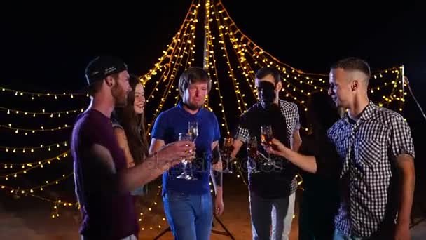 Amigos felizes com champanhe celebram um aniversário na praia à noite — Vídeo de Stock