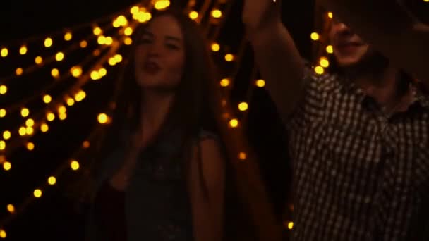 Компания друзей танцует ночью с бенгальскими огнями в руках — стоковое видео