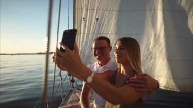 Güzel genç çift selfie gemide bir yat alıyor.