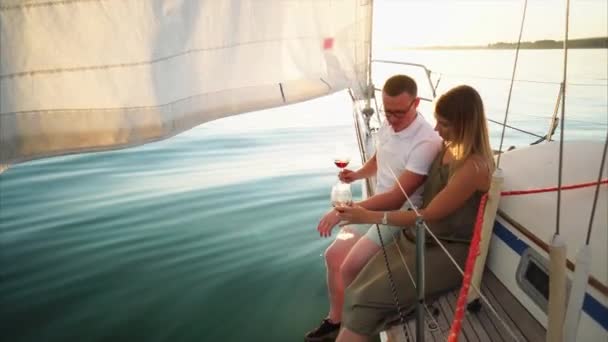 Los recién casados están pasando su luna de miel navegando río y bebiendo vino . — Vídeos de Stock