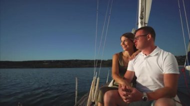 Yelkenli tekne güvertesinde oturan ve yolculuğun tadını seven Çift
