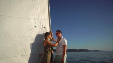 Güzel kadın ve yakışıklı bir yatta, denizde yüzen duruyorsun.