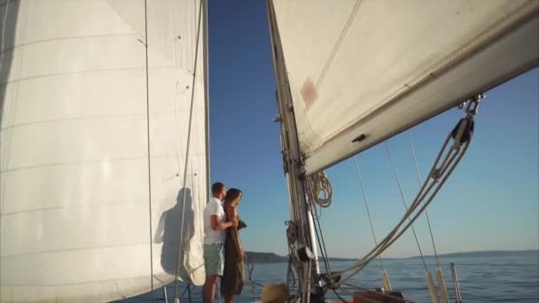 Uomo e donna stanno guardando il tramonto a bordo dello yacht . — Video Stock