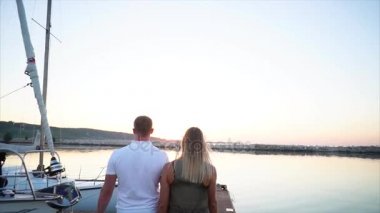 Genç evli çift geziniyor bu akşam bir iskelede arkadan görünüm