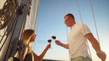 Genç evli çift bir zevk teknede kırmızı şarap içme.