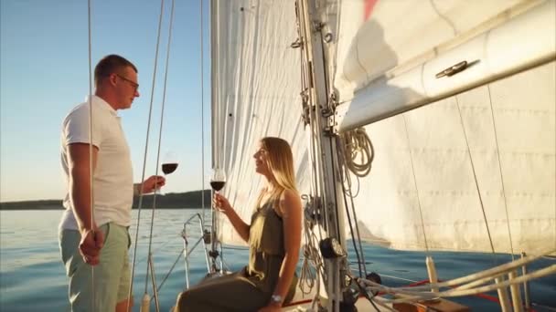 Чоловік і жінка п'ють вино під час романтичного побачення на яхті — стокове відео