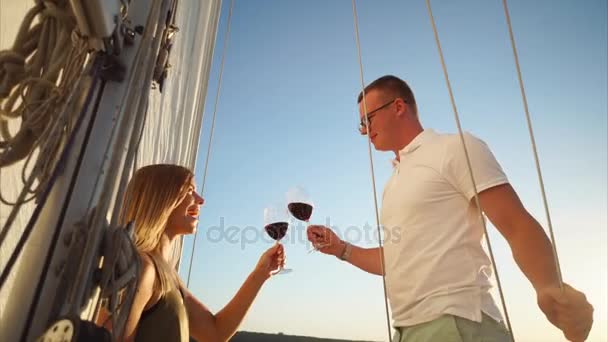 Les jeunes mariés boivent du vin rouge sur un bateau de plaisance . — Video