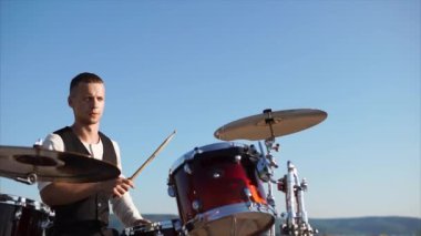 Profesyonel bir müzisyen bir davul ile plakalar ayarla denilen bir müzik aleti çalıyor