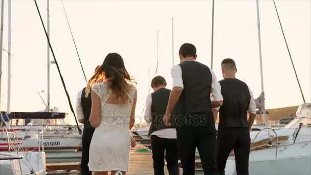 Gente corriendo en el puerto al atardecer — Vídeos de Stock