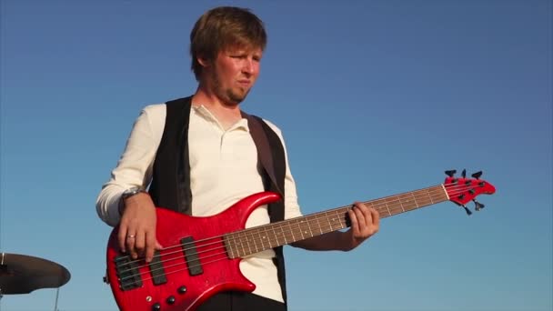 Portrait of a professional musician who plays music, maybe rock, on bass guitar — Stock Video