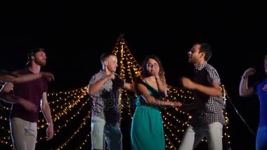 Parti insanları gece kumsalda dans