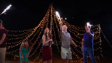 Gece plaj partisi ve havai fişekleri ile dans arkadaşlar