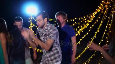 Neşeli insanlar gece kumsalda dans partisi