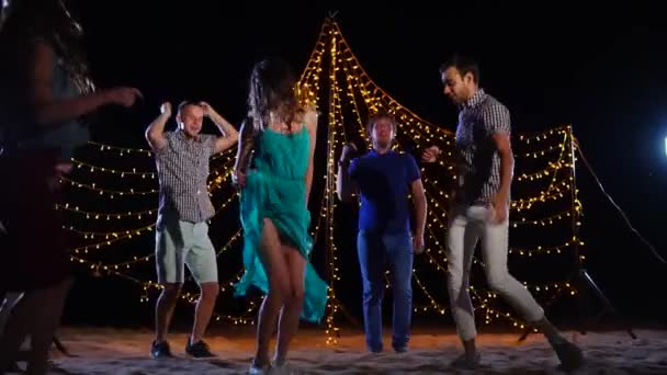 Люди танцуют на ночной пляжной вечеринке — стоковое видео