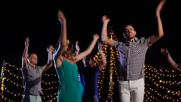 Een groep vrienden dansen op het podium, ze zijn actief springen en zingen — Stockvideo