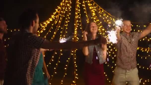 Happy vrienden dansen met wonderkaarsen op nacht feest — Stockvideo