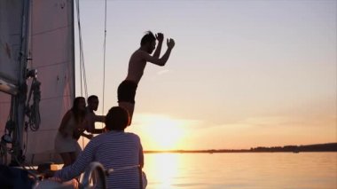 Adam Yatlar nehire günbatımında atlama.