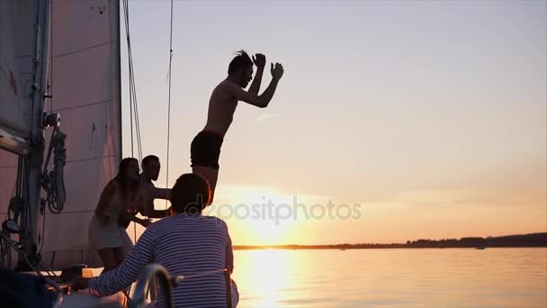 Uomo che salta dallo yacht nel fiume al tramonto — Video Stock