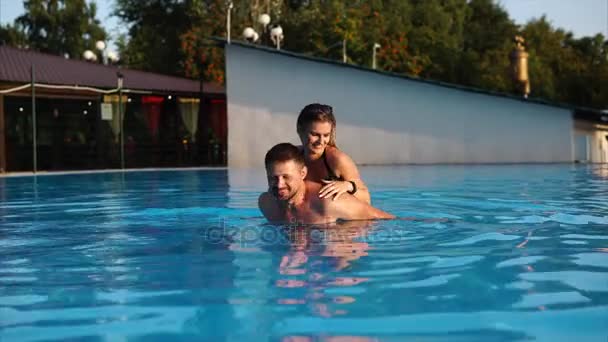 Casal de amantes está nadando em vazio grande uma piscina em um hotel ao ar livre . — Vídeo de Stock