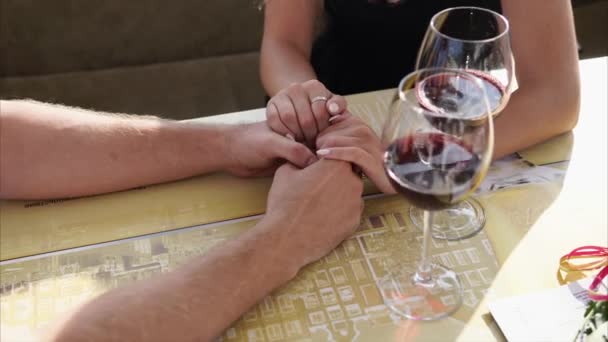 Close-up shot van de handen van liefdevolle man en vrouw die tijd in een restaurant doorbrengen — Stockvideo