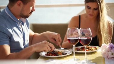 Gündüzleri deniz kenarında bir restoran salata yiyerek kadın ve erkek