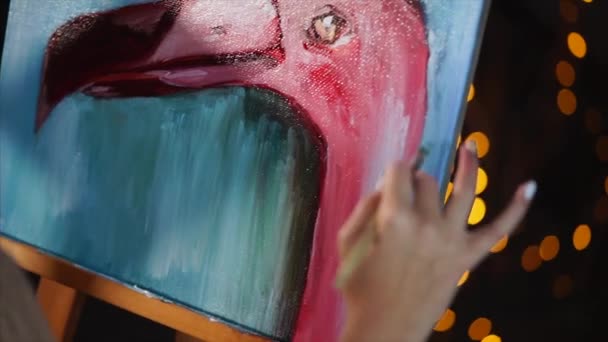 Close-up shot van een schilderij met een flamingo en een hand van kunstenaars, die gebruik maakt van olie — Stockvideo