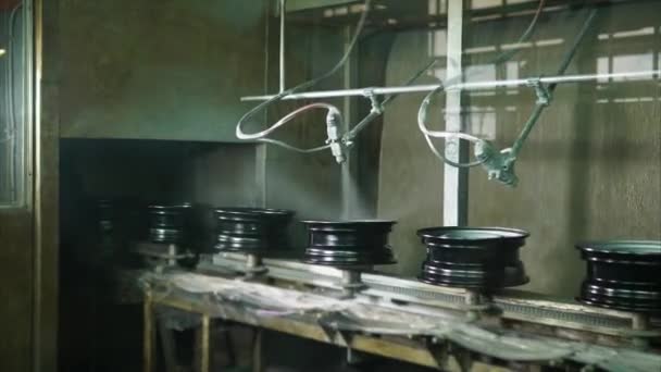 Колеса перемещаются по конвейерной ленте через цех автоматической покраски — стоковое видео