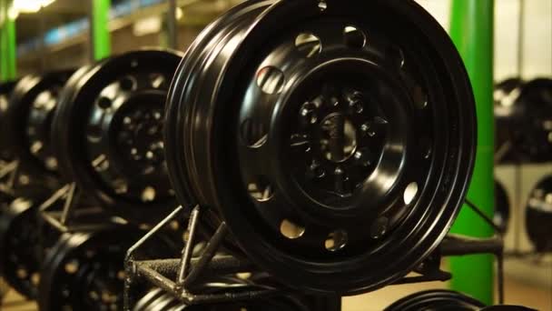 Finished pressed steel discs painted black are standing on a metal racks. — Stock Video