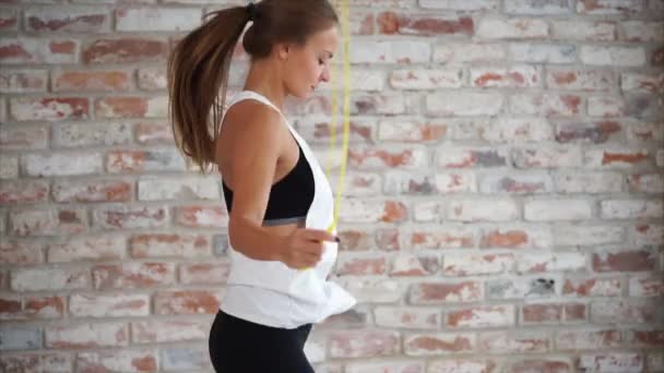 Una mujer en buena forma física salta en la cuerda para fortalecer los músculos en tonus — Vídeo de stock