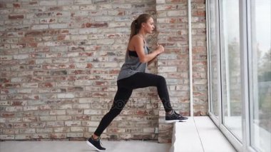 İnanılmaz bir kadın pencerenin kenarında bir egzersiz yapar.