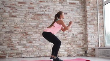 Genç kadının Spor Merkezi ayaklarda güçlendirmek için aktif mekik yapması