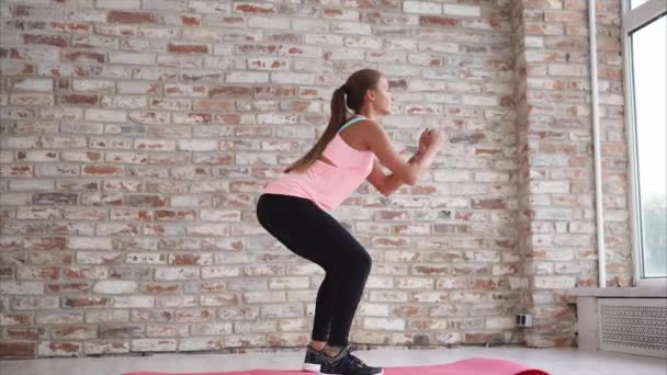 Mujer joven haciendo abdominales activos para fortalecer los pies en el centro deportivo — Vídeos de Stock