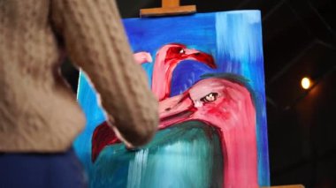 Ressam pembe flamingolar, resim çizmek için bitirme beyaz boya çizgileri yapıyor
