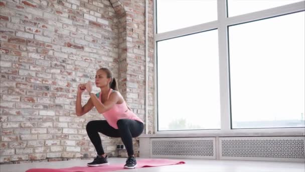 Mulher loira está fazendo exercício matinal no interior moderno de grande sala — Vídeo de Stock