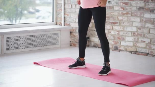 Lichaam van jonge slanke vrouw, squats maken in een hal van fitnessclub. — Stockvideo