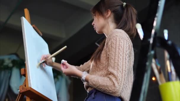 Artista è adescamento tela bianca, in piedi su un cavalletto, prima di disegnare . — Video Stock