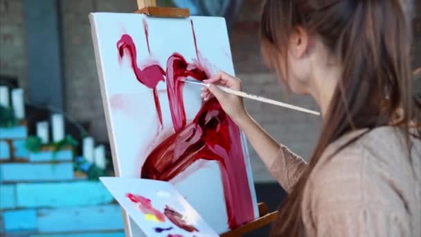 Young painter draws one of her pieces indoor. — Stock Video