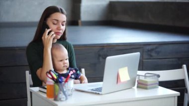 İş anne bir kararname akıllı telefonla konuşuyor ve bir kızı tutuyor