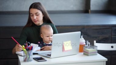 Çalışkan kadın çocuğuyla birlikte ofiste notları alma.