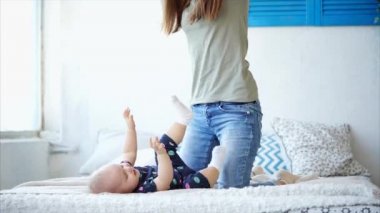 Genç bir anne kızıyla birlikte çalış, bir kadın öper ve küçük bir bebek gıdıklıyor