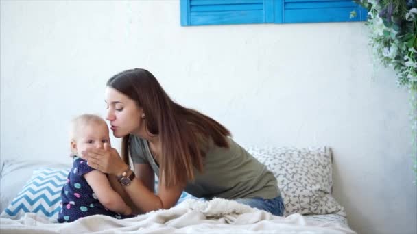 Uma mãe está brincando com sua filha durante o dia, uma mulher está beijando um bebê — Vídeo de Stock