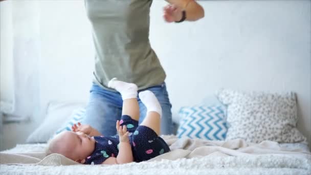Madre juega con su bebé en un dormitorio — Vídeos de Stock
